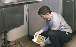 A Zoom Drain specialist applies CitraJet to a commercial kitchen drain