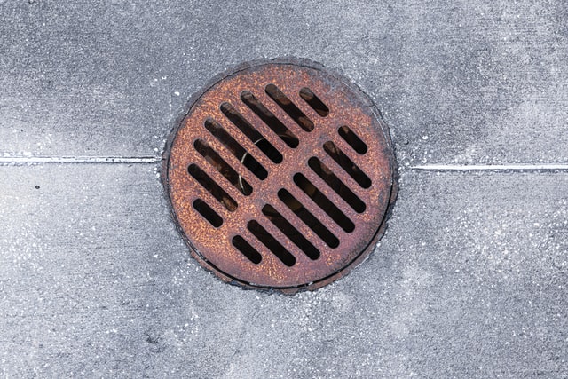 rusty drain surrounded by concrete