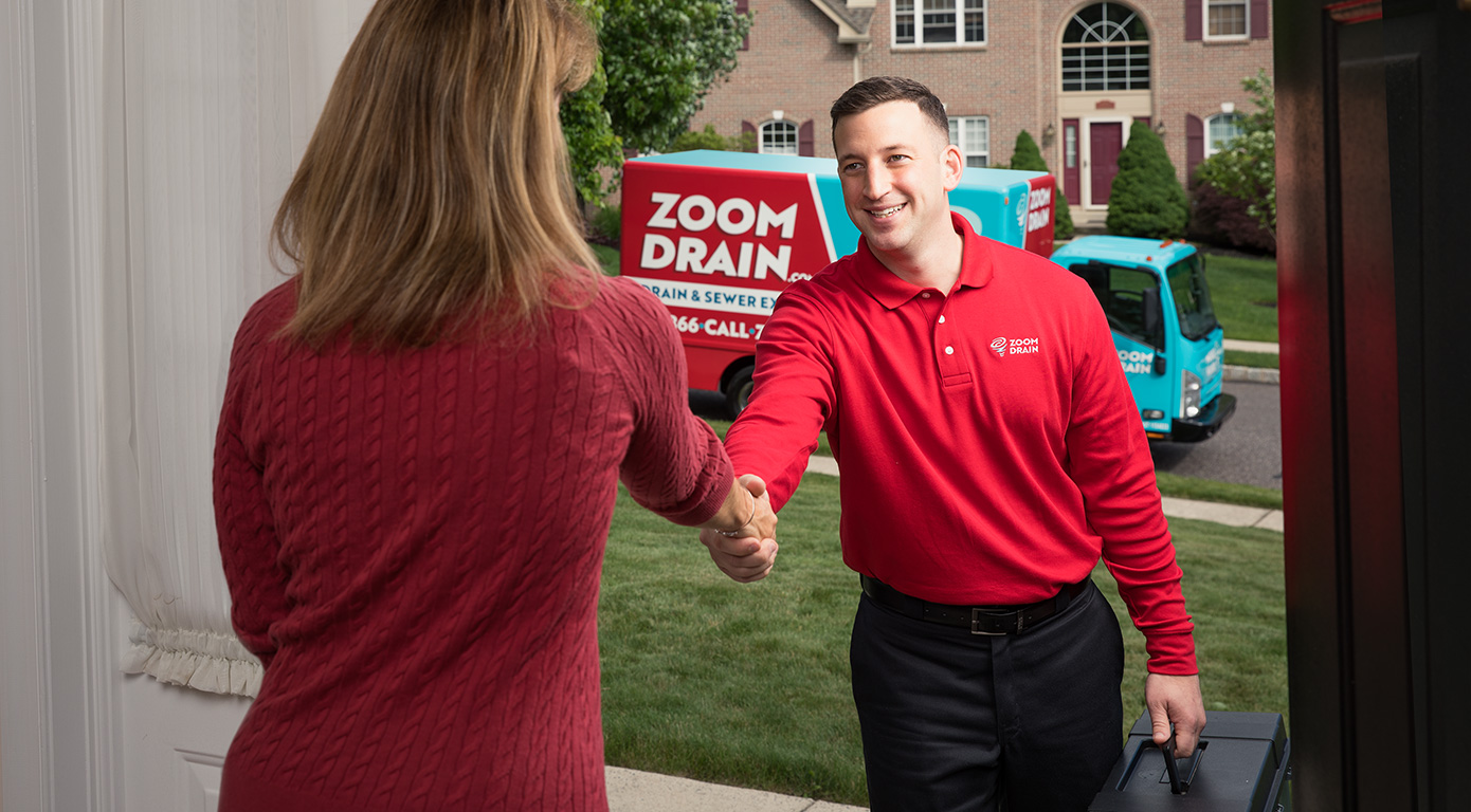 Zoom Drain drain cleaning technician shaking woman's hand at front door in Coatesville