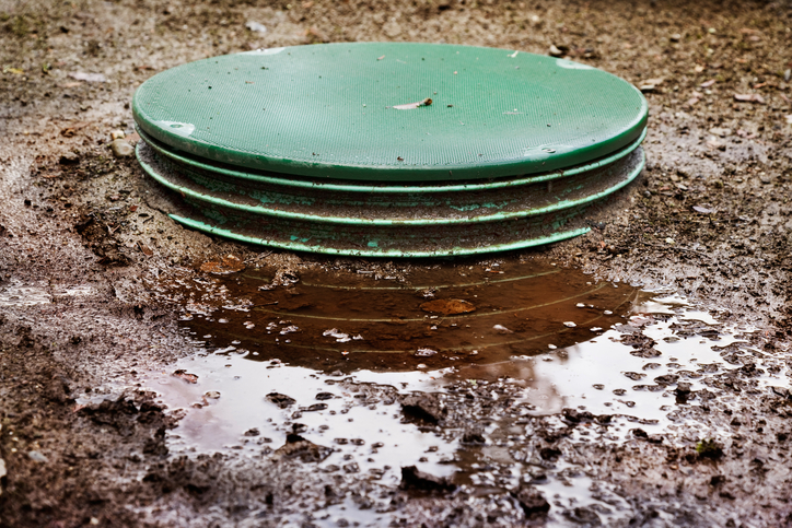 Water leaks around the locking lids of a septic system's tanks.